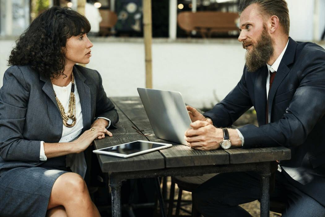 A businessman and a businesswoman talking